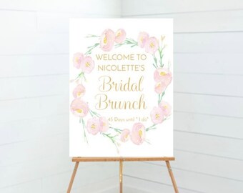 May include: A white sign with a floral wreath border in pink and green. The sign says "Welcome to Nicolette's Bridal Brunch 45 Days until "I do""