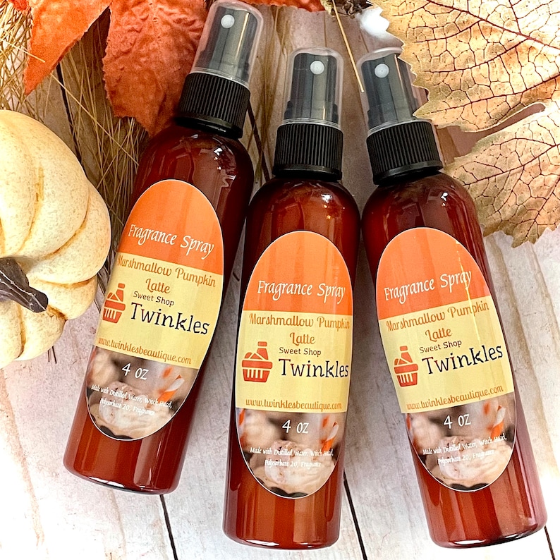 May include: Three 4 ounce brown glass bottles of marshmallow pumpkin latte fragrance spray with a white label that says "Fragrance Spray Marshmallow Pumpkin Latte Sweet Shop Twinkles www.twinklesbeautique.com 4 oz"