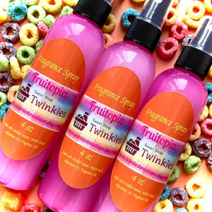 May include: Three pink 4 oz bottles of Fruitopia Sweet Shop Twinkles fragrance spray. The bottles have a white label with rainbow text and a small shopping cart icon. The bottles are sitting on a background of colorful cereal.