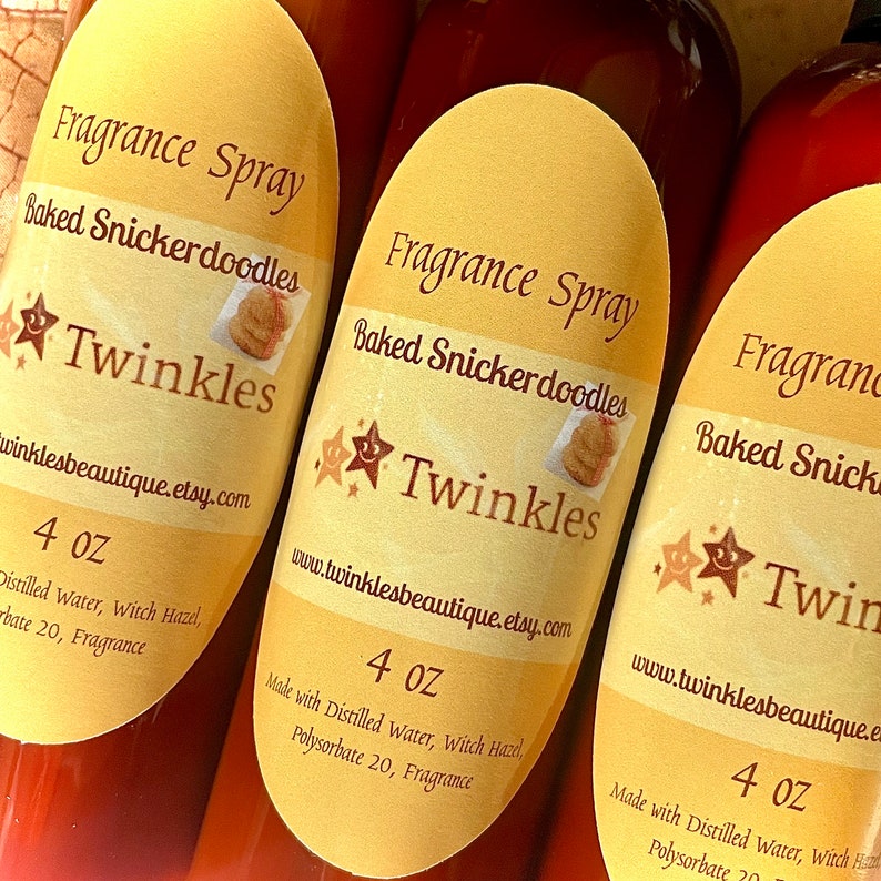 K&ouml;nnte beinhalten: Drei 4 Unzen Flaschen mit Duft-Spray, beschriftet mit "Baked Snickerdoodles" mit einem Stern und einer Zeichnung eines Snickerdoodle-Kekses. Das Etikett tr&auml;gt auch den Schriftzug "Twinkles" und die Website-Adresse "www.twinklesbeautique.etsy.com". Die Flaschen werden mit destilliertem Wasser, Hamamelis, Polysorbat 20 und Duft hergestellt.