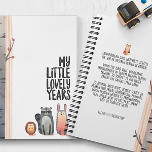 Puede incluir: Un cuaderno de espiral con una cubierta blanca y el texto "My Little Lovely Years" en negro. La cubierta presenta una ilustraci&oacute;n de acuarela de un mapache, un conejo y un erizo en un entorno de bosque. La contraportada tiene una cita en alem&aacute;n sobre el valor de atesorar los recuerdos.