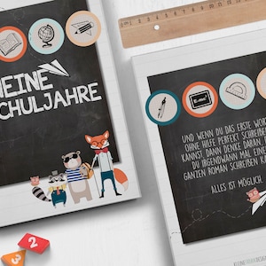 Op de afbeelding: Een zwart schoolbord met de tekst "Meine Schuljahre" (Mijn schooljaren) en verschillende kleurrijke pictogrammen, waaronder een wereldbol, een potlood, een boek en een kompas. Het schoolbord is omgeven door een witte rand en een spiraalbinding.