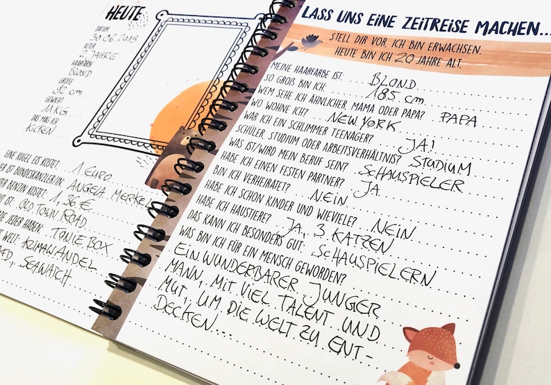 Puede incluir: Un cuaderno con una ilustraci&oacute;n en blanco y negro de un oso en la portada. El cuaderno tiene una encuadernaci&oacute;n en espiral y est&aacute; abierto en una p&aacute;gina con texto escrito a mano en alem&aacute;n. El texto incluye preguntas sobre la vida de una persona, como el color de su cabello, su altura y si tiene hijos. La p&aacute;gina tambi&eacute;n incluye un dibujo de un zorro.