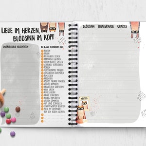 Puede incluir: Una libreta de espiral gris y blanca con una ilustraci&oacute;n de un gato en la portada. El texto de la portada dice "Liebe im Herzen, Bl&ouml;dsinn im Kopf". La libreta tiene una lista de "Unvergessliche Heldentaten" y "Ich kann besonders gut" con una lista de actividades.