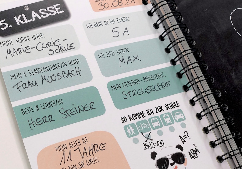 Op de afbeelding: Een schoolplanner met een zwart-witte pandabeerillustratie. De planner heeft een zwarte spiraalbinding en bevat een checklist voor het klaar maken voor school, inclusief lopen, fietsen, de bus nemen en de trein nemen. De planner bevat ook een sectie voor persoonlijke informatie, zoals de naam van de leerling, de leeftijd, de naam van de school, de naam van de leraar en de favoriete snack.