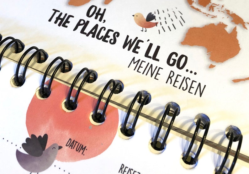 Puede incluir: Un cuaderno blanco de espiral con el texto "Oh, the places we'll go... Meine Reisen" y una peque&ntilde;a ilustraci&oacute;n de un p&aacute;jaro. El cuaderno tiene un fondo de acuarela rosa y naranja.
