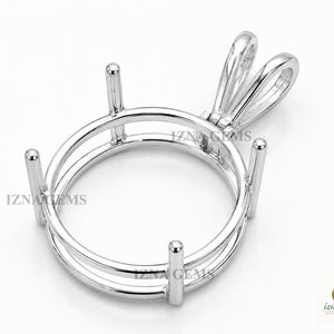 Peut inclure: Une monture de pendentif en métal argenté composée d'un cadre circulaire avec quatre griffes verticales destinées à maintenir une pierre précieuse. La pièce comprend une bélière polie sur le dessus. Le texte IZNA GEMS est visible sur l'objet.
