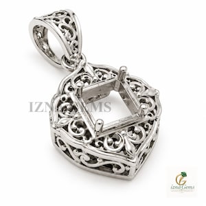Puede incluir: Un colgante de metal plateado con un intrincado diseño de filigrana y un engaste de garras cuadrado para una piedra preciosa. La pieza incluye una reasa decorativa en la parte superior y muestra el texto IZNA GEMS en el centro.