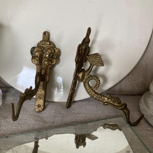 FRANKEICH CONJUNTO 2 ganchos de parede dourados antigos GOLFINHO latão altura aprox. 12,5 cm cabideiro gancho para casaco golfinho homem mulher pátina vintage