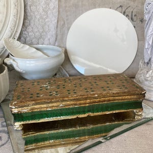 May include: A wooden box with a gold and green finish. The top of the box is decorated with a pattern of small green dots on a gold background. The box is open, revealing a second layer with a green border.