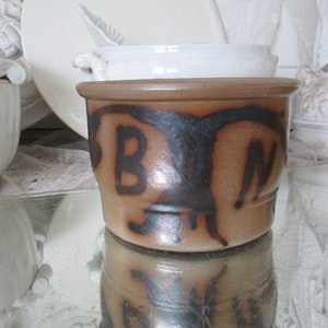 May include: A brown ceramic jar with a black design of a bird and the letters "B" and "N".