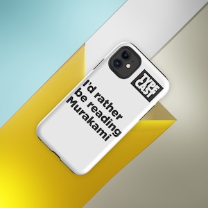 Peut inclure: Coque de téléphone iPhone blanche avec du texte noir qui dit "I'd rather be reading Murakami" et un logo noir qui dit "Type Cast".
