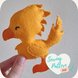 May include: A yellow felt sewing pattern for a small bird with orange feet. The pattern is called "Sewing Pattern" and is available as a PDF download.