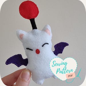 May include: A white plush toy with a red balloon on top and purple wings. The toy has a cute face with black eyes and a red nose. The text "Sewing Pattern PDF" is on a heart-shaped background.