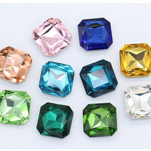 May include: Assortment of ten square-shaped, faceted glass rhinestones in various colors, including pink, blue, gold, green, and clear.