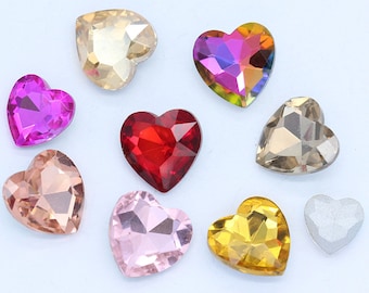 May include: Assortment of heart-shaped glass rhinestones in various colors, including pink, red, gold, clear, and iridescent. The rhinestones are perfect for crafting and decorating.