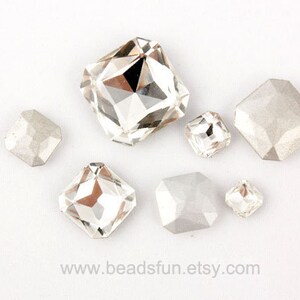 May include: Assortment of clear and opaque glass rhinestones in various shapes and sizes. The rhinestones are faceted and have a shiny finish.