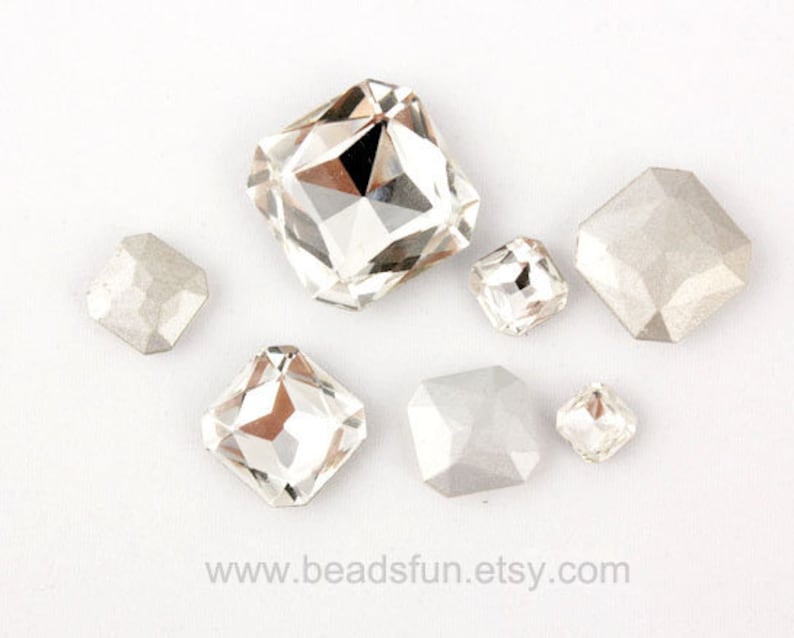 May include: Assortment of clear and opaque glass rhinestones in various shapes and sizes. The rhinestones are faceted and have a shiny finish.