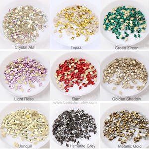 May include: Assortment of 10 colors of small, faceted, diamond-shaped rhinestones in white bowls. Colors include crystal AB, topaz, green zircon, light rose, Siam, golden shadow, jonquil, hematite grey, and metallic gold.