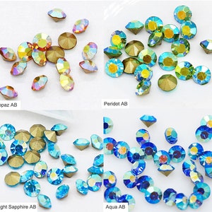 Pu&ograve; includere: Assortimento di strass di vetro iridescenti in quattro colori: topazio, peridoto, zaffiro chiaro e acquamarina. Ogni colore &egrave; mostrato su uno sfondo bianco.