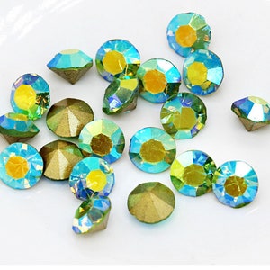 Pu&ograve; includere: Assortimento di strass verdi e blu iridescenti. Gli strass hanno un design sfaccettato e un retro piatto.