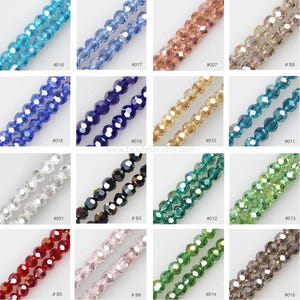 May include: Assortment of 15 strands of faceted glass beads in various colors, including clear, blue, green, red, and brown. Each strand is labeled with a number.