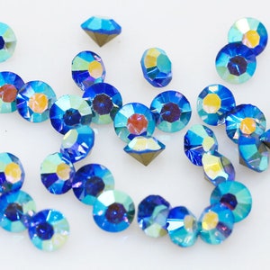Pu&ograve; includere: Assortimento di strass blu iridescenti, perfetti per l'artigianato e la creazione di gioielli.