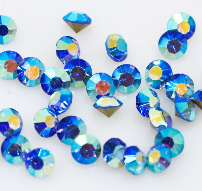 Pu&ograve; includere: Assortimento di strass blu iridescenti, perfetti per l'artigianato e la creazione di gioielli.