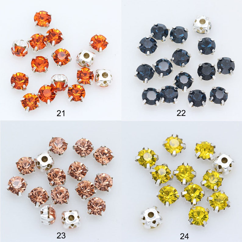 May include: Assortment of 12mm round rhinestones with silver settings. The rhinestones are available in four colors: orange, blue, brown, and yellow. The rhinestones are arranged in groups of four, with each group labeled with a number from 21 to 24.