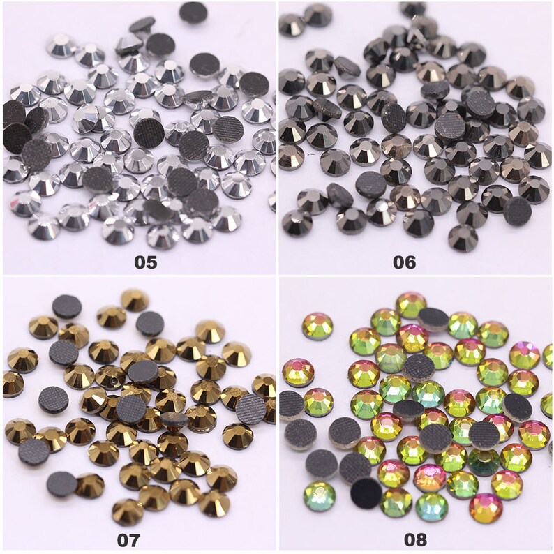 May include: Assortment of rhinestones in various colors, including silver, black, gold, and iridescent green. The rhinestones are arranged in four groups, each with a number below it: 05, 06, 07, and 08.
