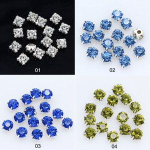 May include: Assortment of 12 round rhinestones with silver settings. The rhinestones are available in four colors: clear, light blue, dark blue, and green.