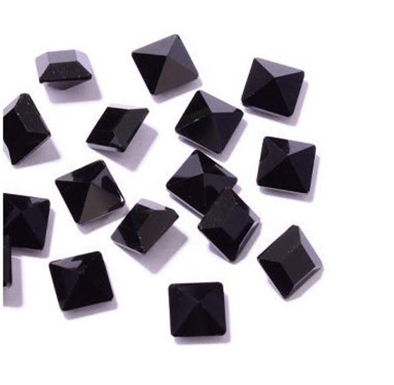 May include: A scattering of black square pyramid-shaped rhinestones.