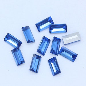 May include: Assortment of blue rectangular glass rhinestones, ideal for crafting and jewelry making.