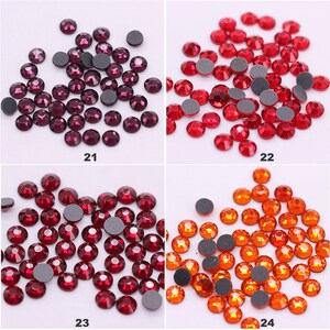 May include: Assortment of four different colors of rhinestones with flat backs. The colors are purple, red, burgundy, and orange. Each color is shown in a separate square.