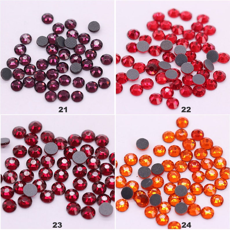 May include: Assortment of four different colors of rhinestones with flat backs. The colors are purple, red, burgundy, and orange. Each color is shown in a separate square.