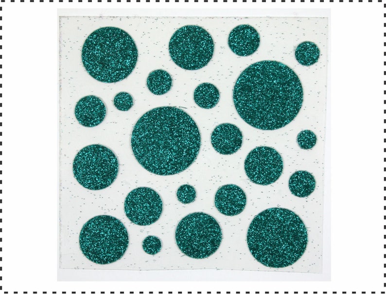 Op de afbeelding: Een vel wit papier met teal glittercirkels in verschillende maten.