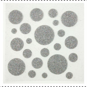Op de afbeelding: Een vel met zilveren glitter stickers in verschillende maten, perfect om een ​​toets van glitter toe te voegen aan knutselwerk, kaarten en andere projecten.