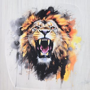 Könnte beinhalten: Eine Illustration im Aquarellstil eines brüllenden Löwen. Die Löwenmähne ist eine Mischung aus Orange, Gelb und Braun mit schwarzer Umrandung. Das Maul des Löwen ist geöffnet und zeigt scharfe Zähne. Graue und orangefarbene Spritzer umgeben den Löwen.