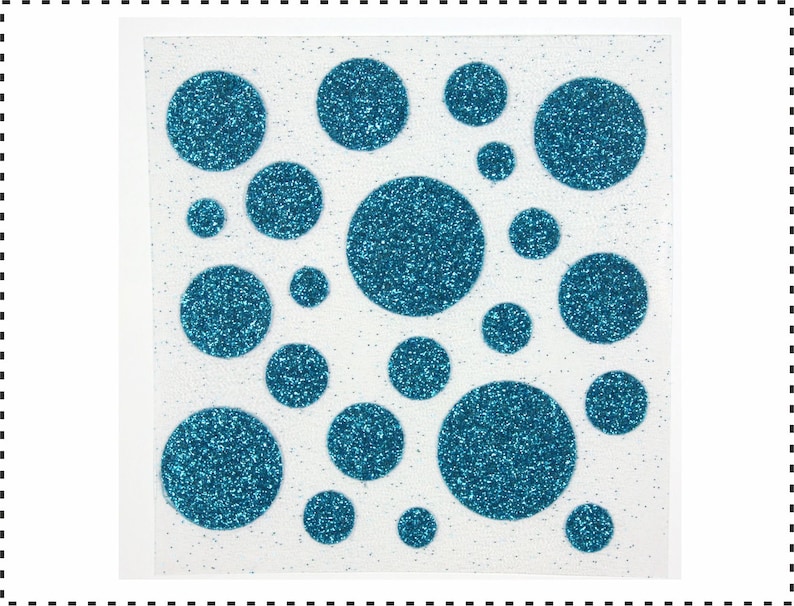 Op de afbeelding: Een vel wit papier met blauwe glitter stippen in verschillende maten. De stippen zijn in een willekeurig patroon gerangschikt.