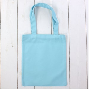 May include: A light blue tote bag made of cotton fabric. The bag has two handles and is empty.