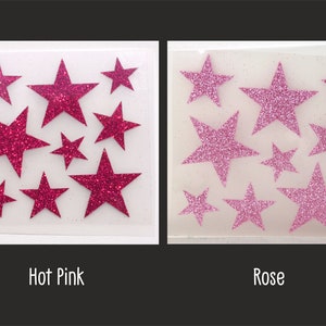 Op de afbeelding: Twee vellen met zelfklevende glittersterren. Het vel links heeft felroze sterren. Het vel rechts heeft roze sterren. Beide vellen hebben sterren in verschillende maten.