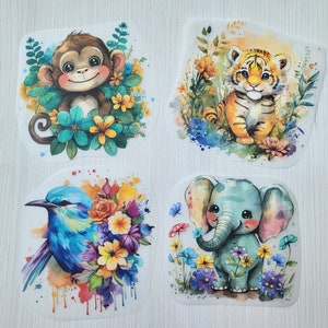 Könnte beinhalten: Vier Bügelbilder mit bunten Illustrationen eines Affen, eines Tigers, eines Vogels und eines Elefanten. Jedes Bügelbild ist von Blumen und Blättern umgeben.