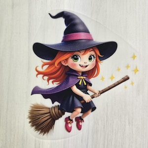 Könnte beinhalten: Cartoon-Illustration einer lächelnden Hexe auf einem Besen. Die Hexe hat rotes Haar, grüne Augen und trägt einen schwarzen Hut mit lila Band, einen lila Umhang und ein schwarzes Kleid. Der Besen ist braun, und gelbe Sterne ziehen hinterher.