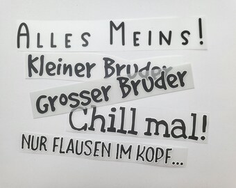 Op de afbeelding: Vijf zwart-witte stickers met Duitse zinnen. De stickers luiden "ALLES MEINS!" "Kleiner Bruder" "Grosser Bruder" "Chill mal!" en "NUR FLAUSEN IM KOPF..."