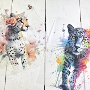Könnte beinhalten: Zwei transparente Bögen mit Leoparden-Illustrationen. Der linke Bogen zeigt einen Leoparden mit einer pfirsichfarbenen Rose und zarten floralen Akzenten. Der rechte Bogen zeigt einen Leoparden mit lebhaften, bunten Aquarellspritzern und Schmetterlingen.