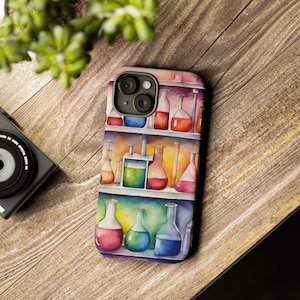 May include: A watercolor illustration of a shelf filled with colorful glass beakers and flasks. The beakers and flasks are filled with different colored liquids. The illustration is on a phone case.