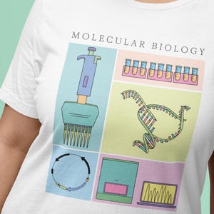 Puede incluir: Una camiseta blanca con el texto "MOLECULAR BIOLOGY" impreso en negro. La camiseta presenta una ilustración colorida de varias herramientas y conceptos de biología molecular, incluyendo una pipeta, tubos de ensayo, una doble hélice de ADN, una molécula de ADN circular y una máquina de electroforesis en gel.