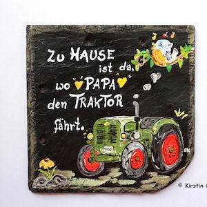 Puede incluir: Letrero de pizarra pintado a mano con un tractor verde y el texto "Zu Hause ist da, wo Papa den Traktor f&auml;hrt." Incluye detalles de p&aacute;jaros y flores. El letrero mide aproximadamente 20 cm de ancho y 18 cm de alto.
