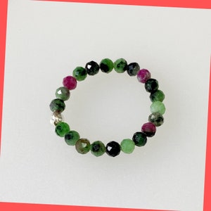 May include: A green, pink and black gemstone bracelet with faceted beads.