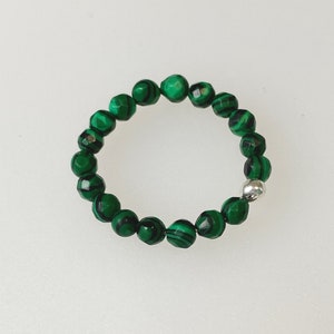 May include: A green malachite beaded ring with a silver clasp.